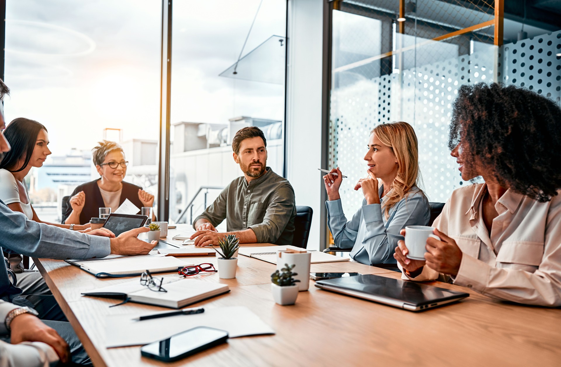 Concept d’entreprise. Des professionnels multinationaux, des hommes d’affaires discutant de sujets quotidiens par table dans un bureau moderne. Réunion d’affaires.